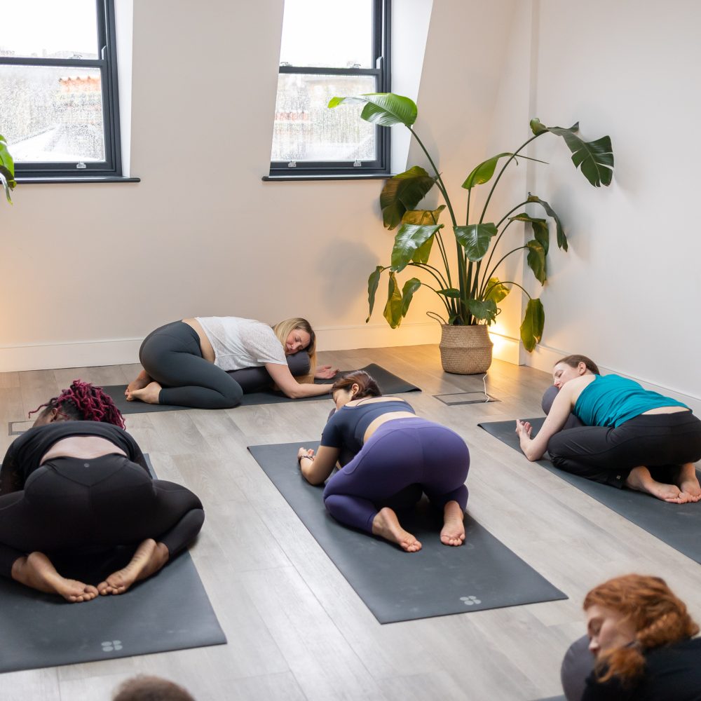 Group of yoga students and 1 teacher in Childs pose at Blackheath Yoga studio