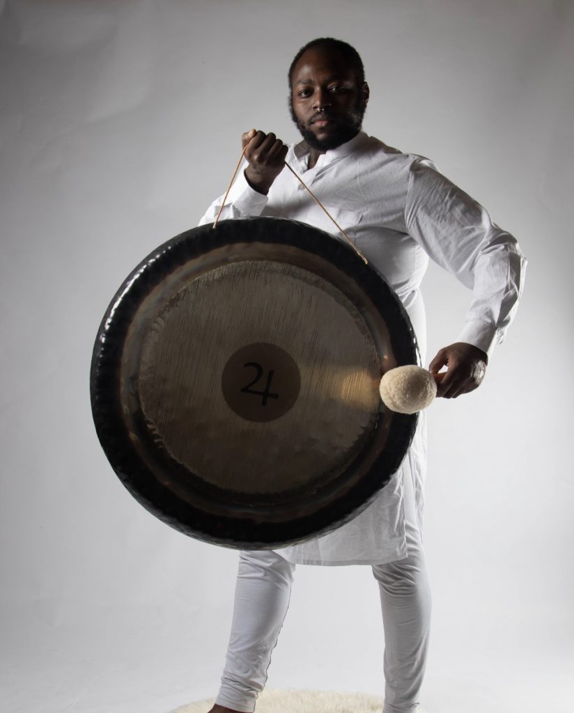 Junior Valentine dressed white holding a gong